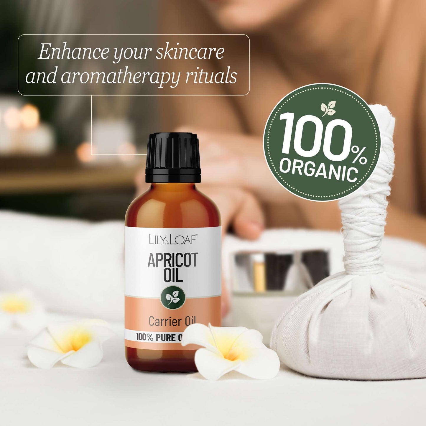 Bottle of apricot oil with a 100% organic label on a blurred background of a spa setting.
