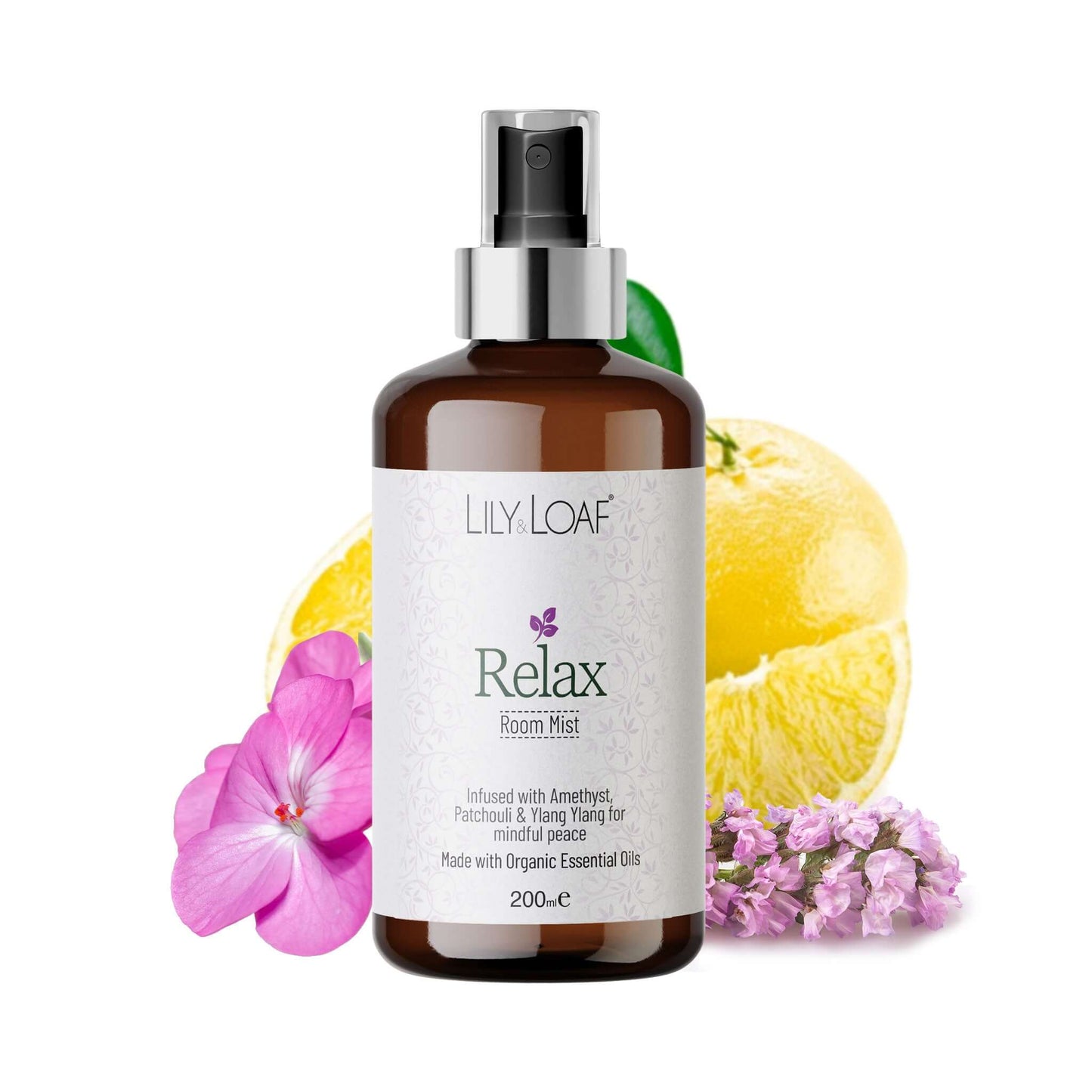 Bottle of Lily & Loaf Relax Room Mist with lemon slices and flowers on a white background