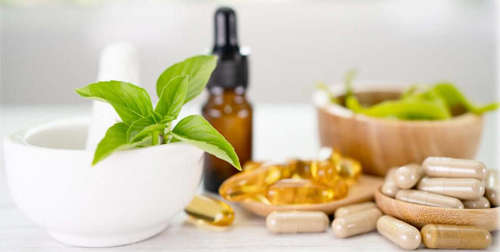 Herbal supplements and capsules with a mortar and pestle, representing Lily & Loaf's commitment to natural health solutions.