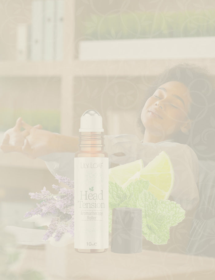 Woman holding a rollerball of Head Tension Aromatherapy oil bottle in an office setting