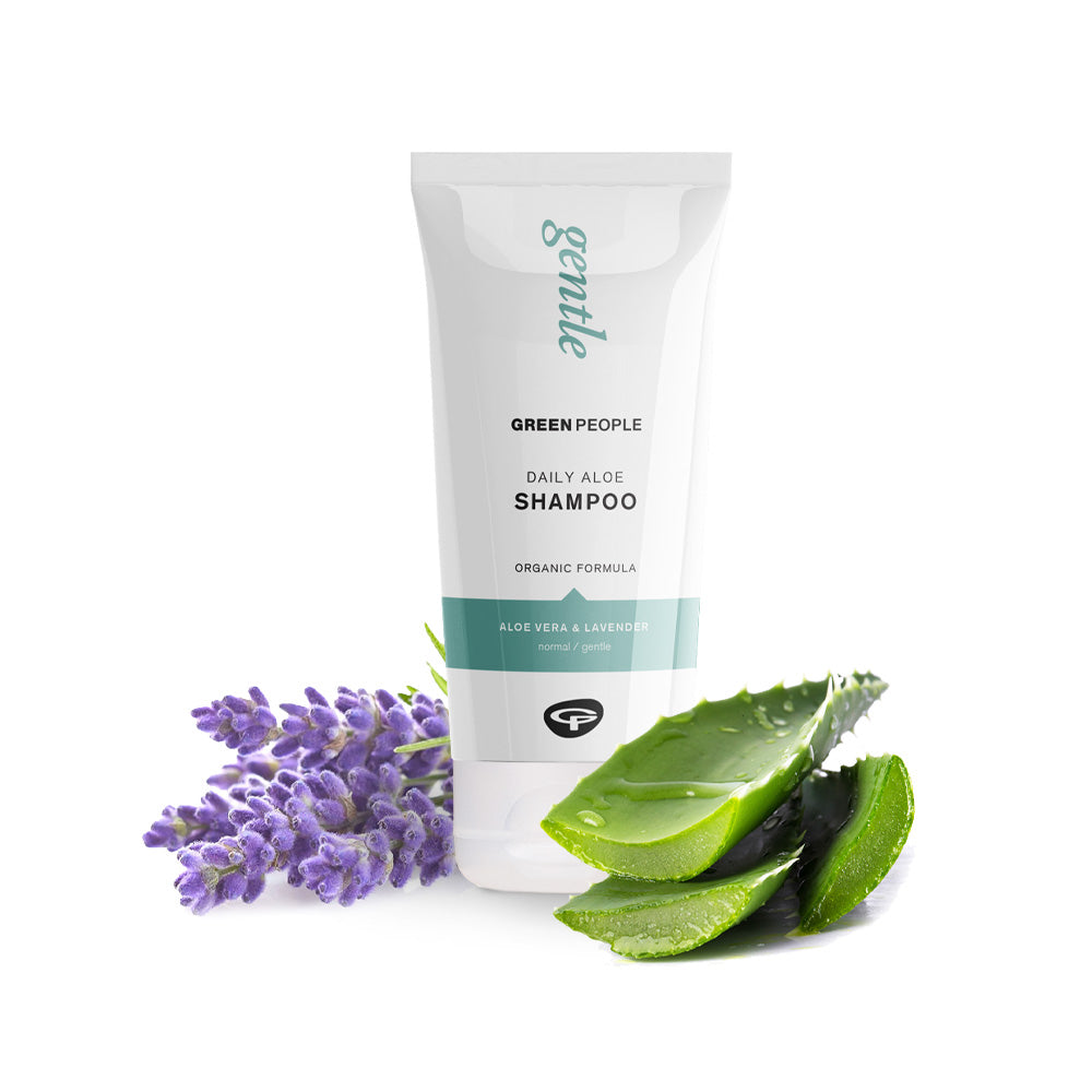 Green People Daily Aloe Shampoo with aloe vera leaves and lavender flowers on a white background