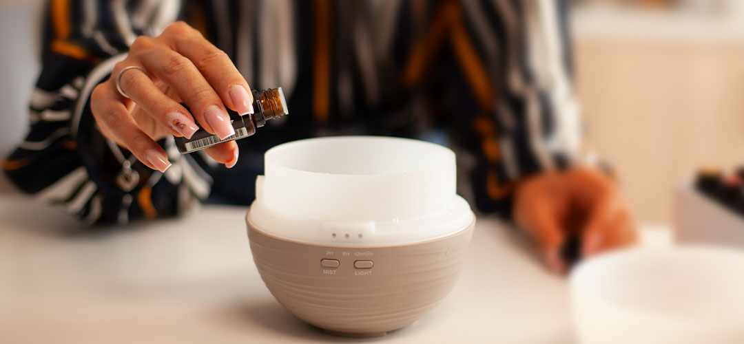 lady adding essential oil to a diffuser