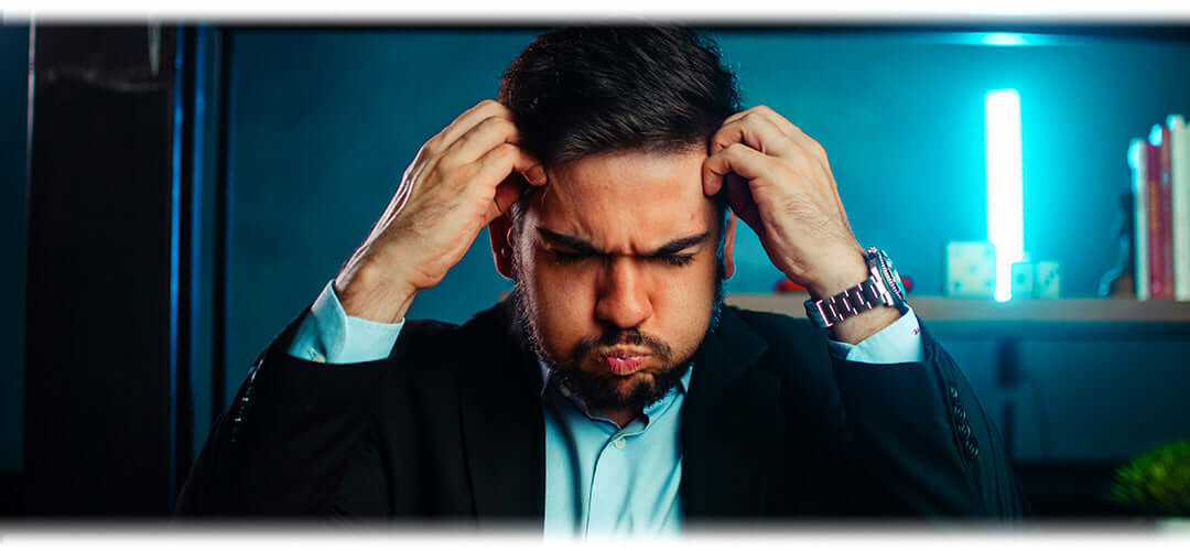A man holding his hands by his head looking stressed
