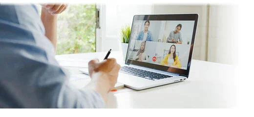 A man working from home, sharing a meeting on a laptop