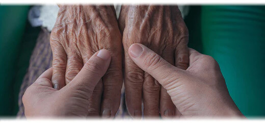 Two people holding hands, one set is young and the other old