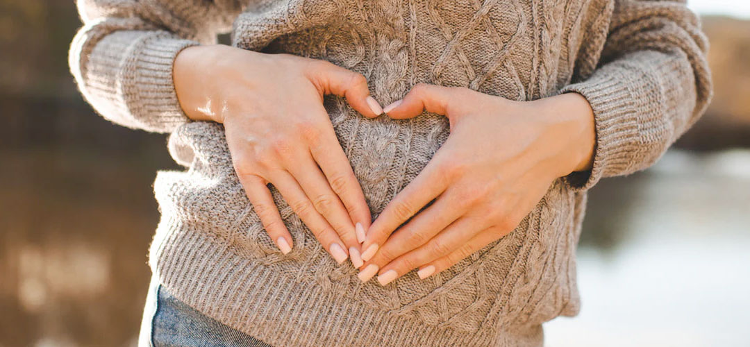 Person forming a heart shape over their stomach, symbolising the importance of gut health in detoxification and the benefits of Pre+Pro 15