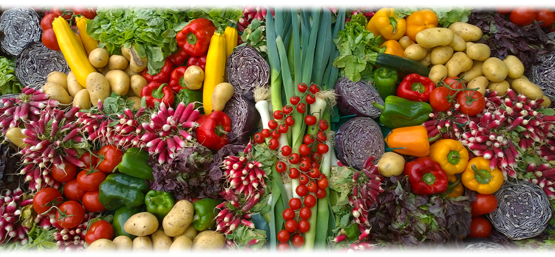 Colourful display of vegetables including peppers, tomatoes, and leafy greens, highlighting natural sources of vitamin A and its health benefits