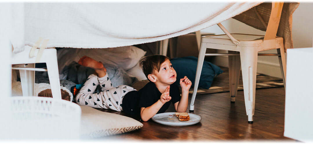Children engaged in indoor activities such as making duvet dens
