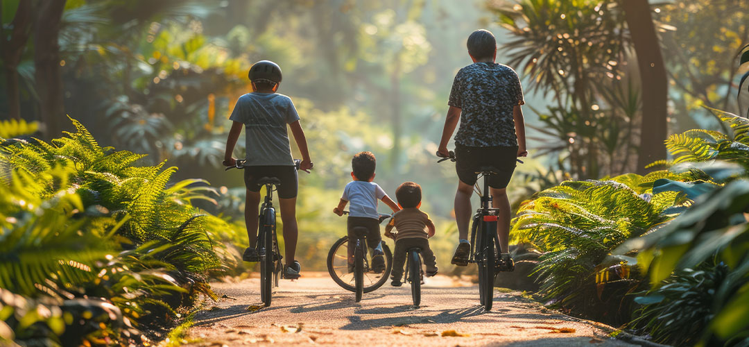 Family cycling through a sunlit forest path, promoting outdoor exercise and healthy living.