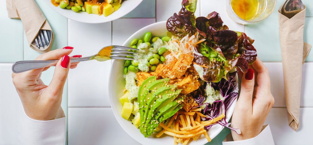 A dinner plate of delicious healthy foods such as avocado, chicken and salad