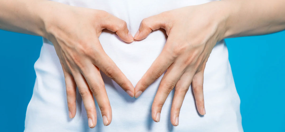 finger constructing a heart shape over tummy