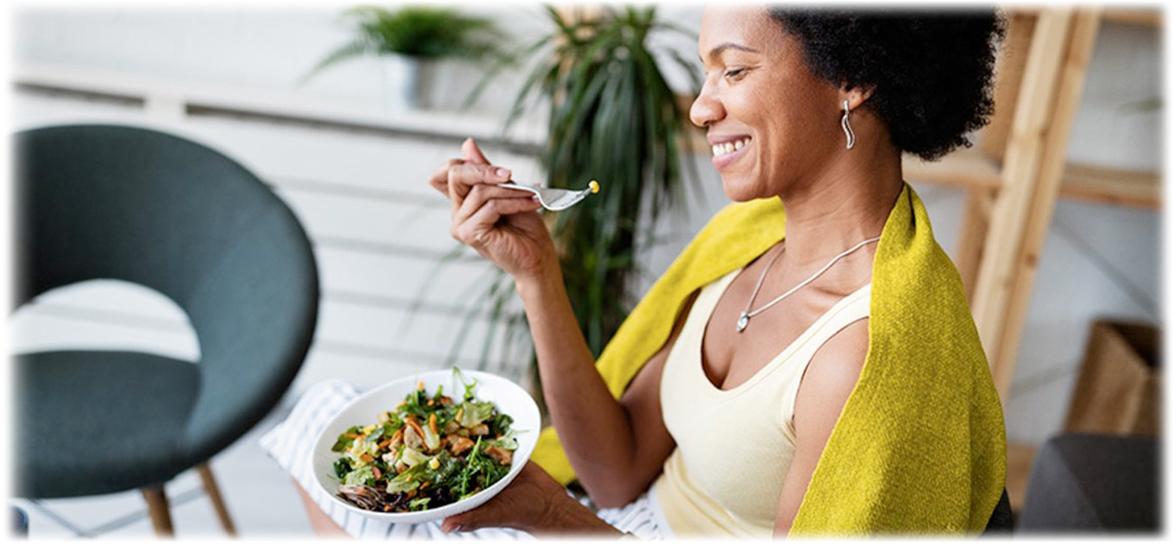 A woman eating a healthy, nutritious salad