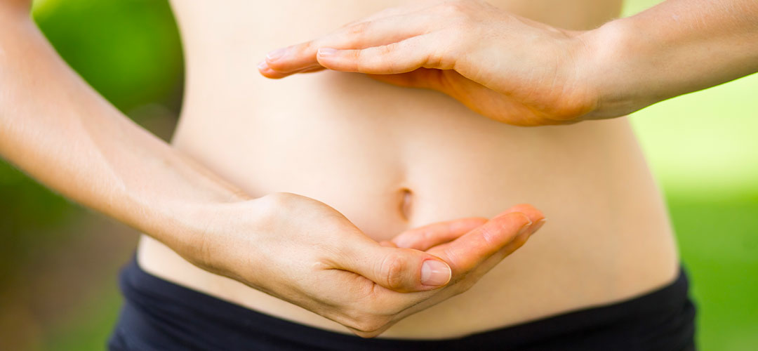 Hands gently framing the stomach area, symbolising digestive health and daily probiotic support.