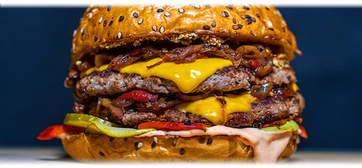 A huge fast food burger with all the extras