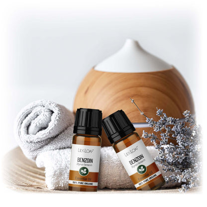 Two bottles of Lily & Loaf Benzoin oil with a wooden diffuser and decorative elements on a light background.