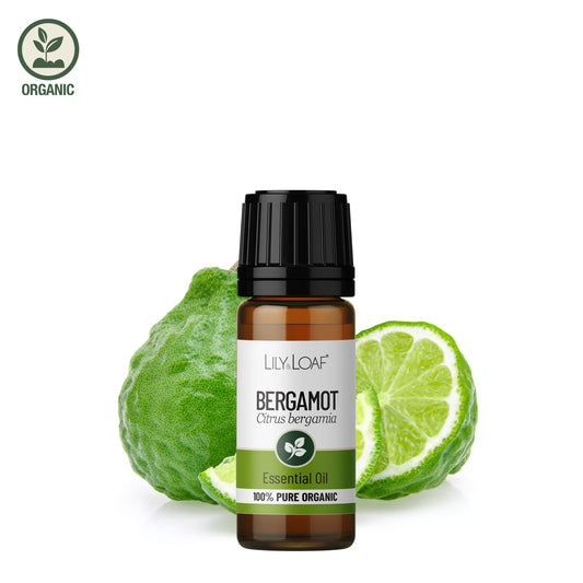 Lily & Loaf Organic Bergamot Essential Oil bottle in front of a bergamot