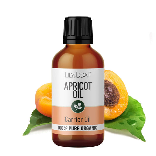 Bottle of Lily & Loaf Apricot Oil with apricot fruit and leaves on a white background