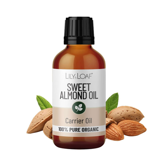 Bottle of Lily & Loaf Sweet Almond Oil with almonds and leaves on a white background