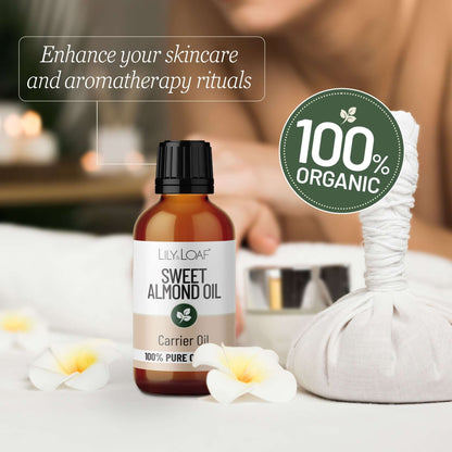 Bottle of sweet almond oil with a 100% organic label, surrounded by flowers and a blurred background.