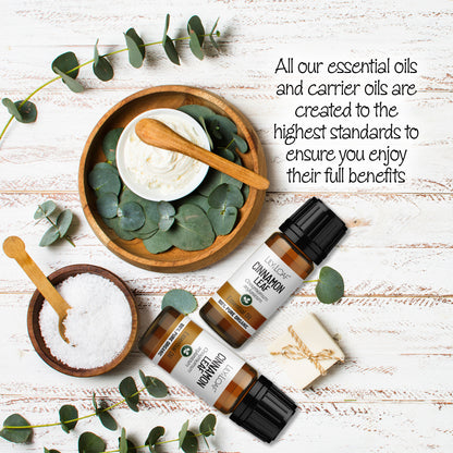 Lily & Loaf Cinnamon Leaf Organic Essential Oil surrounded by wooden bowls filled with moisturising cream