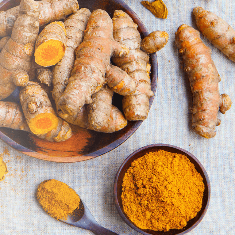 Turmeric roots and curcumin powder in a bowl