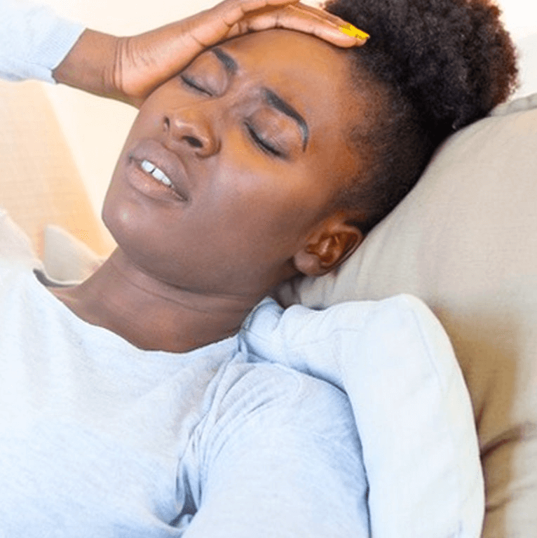 A woman holding her head in pain