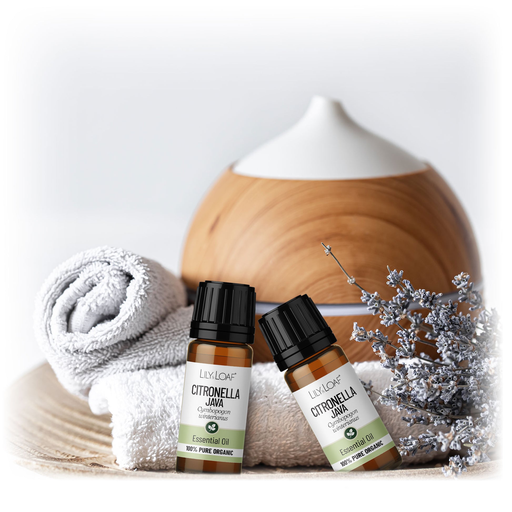 Lily & Loaf Citronella oils resting on white towels with a diffuser in the background