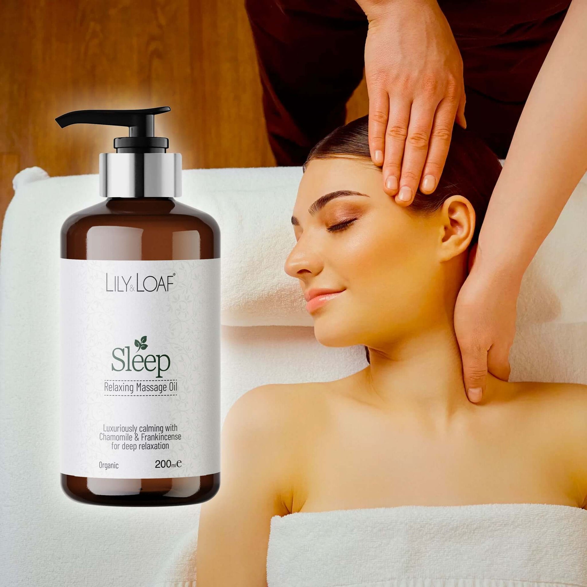 Woman receiving a massage with a bottle of Lily Loaf Sleep Relaxing Massage Oil in the foreground.