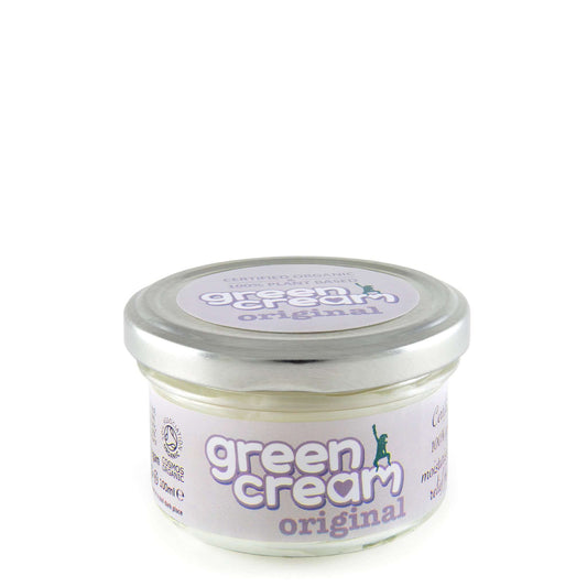 A jar of Green Cream Original day cream in a small clear glass jar with a silver lid.