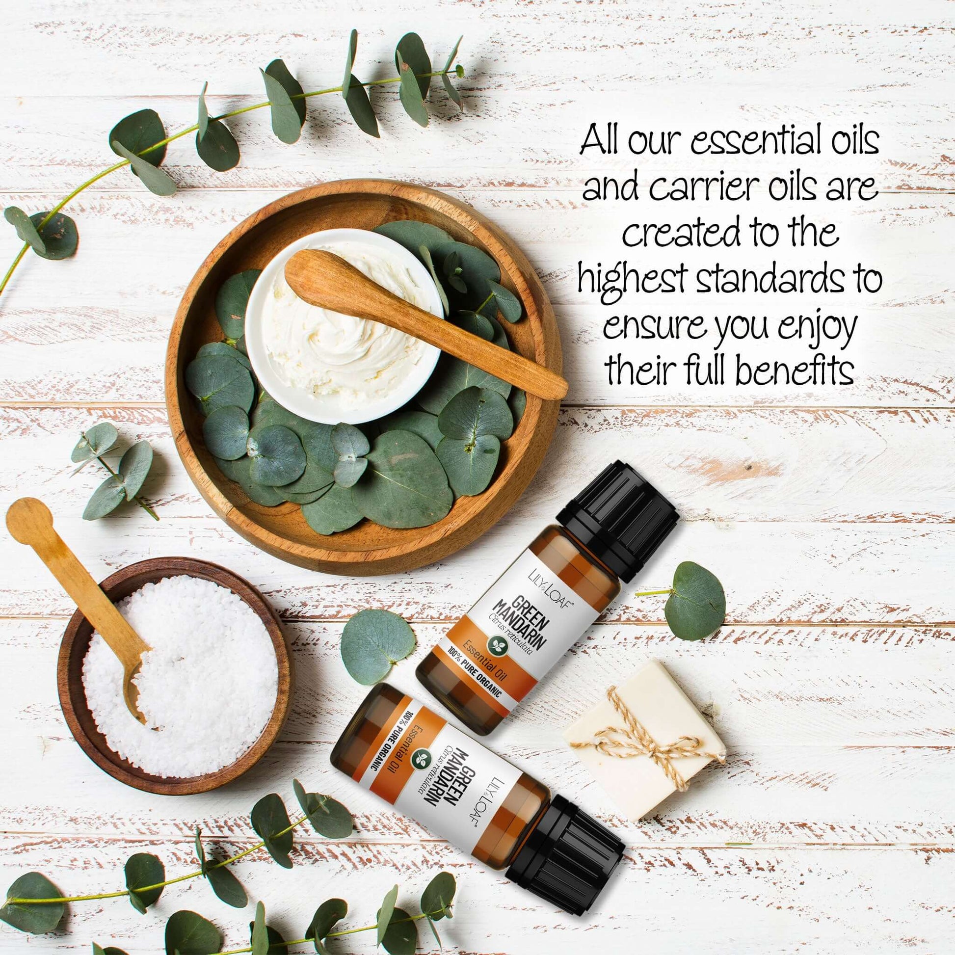Green Mandarin Essential oil with eucalyptus leaves on a wooden surface