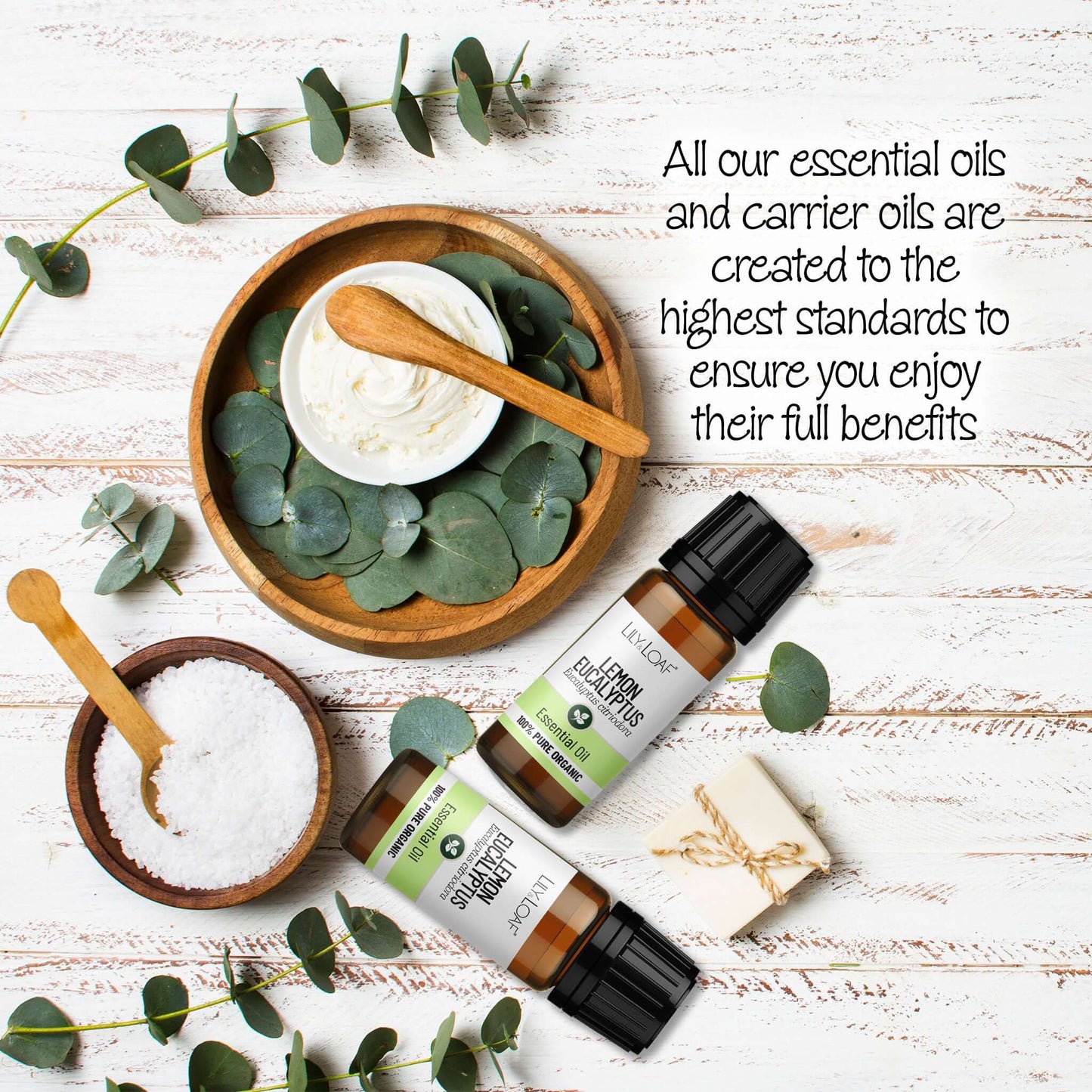 Lemon Eucalyptus Essential Oil surrounded by eucalyptus leaves, wooden bowls and spoons on a wooden background