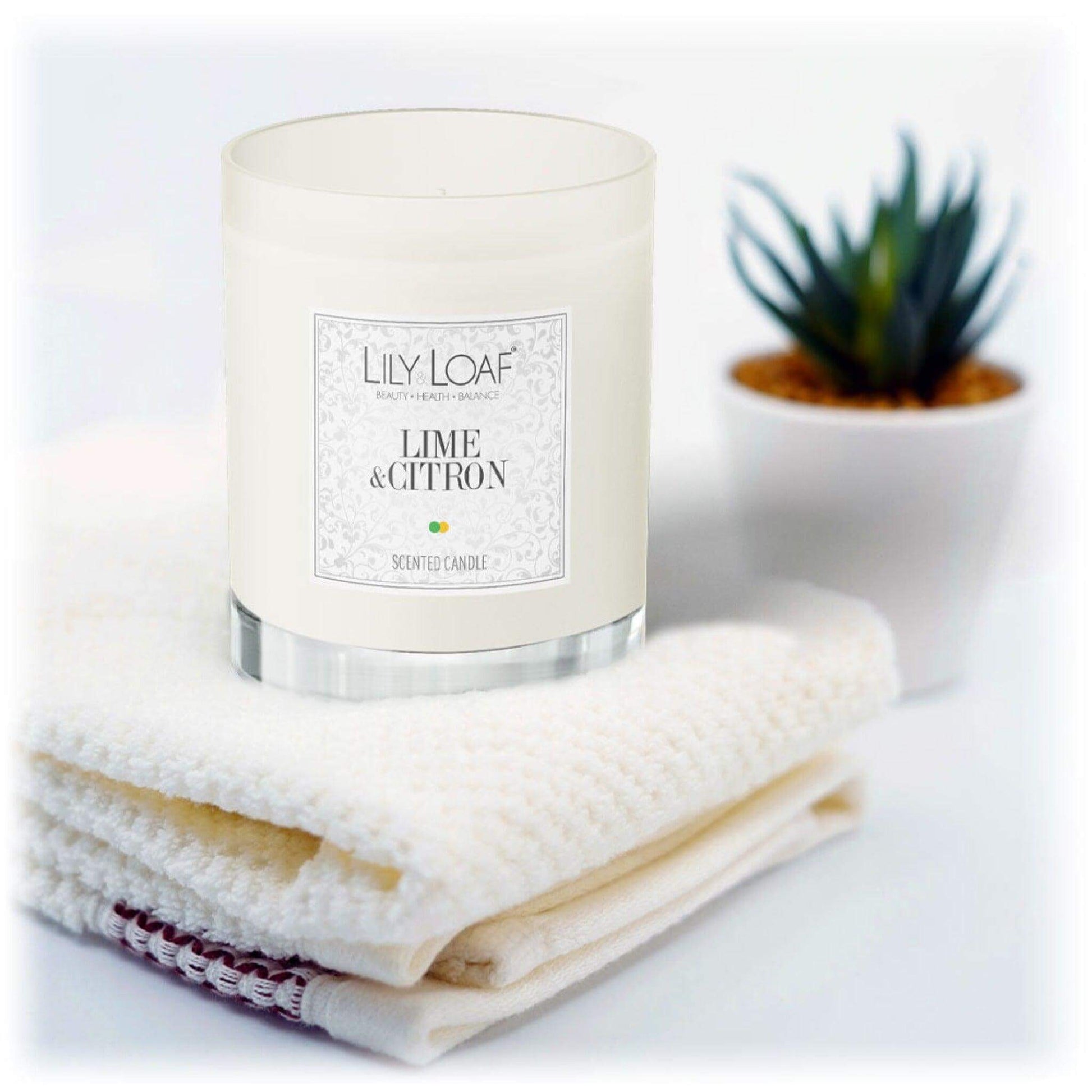 Lily & Loaf Lime & Citron Soy Wax Candle resting on white towels