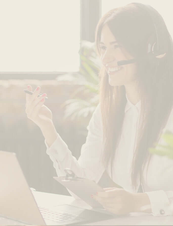 An office worker talking on a headset sat in front of a laptop
