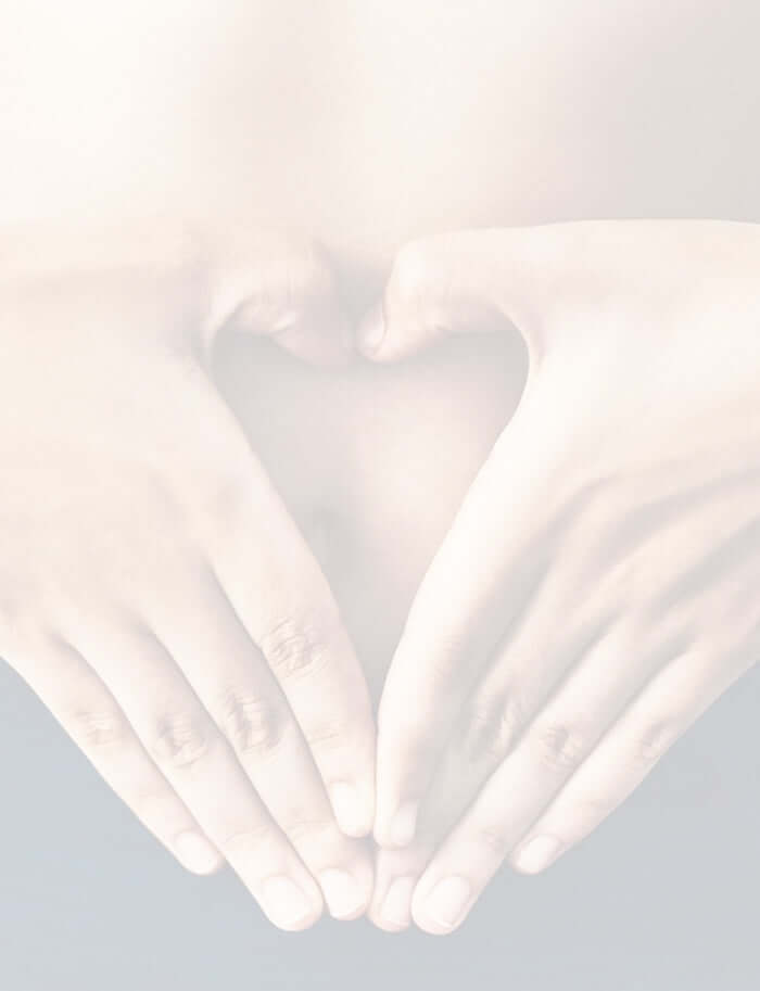 a woman with her finger creating a heart shape on the tummy