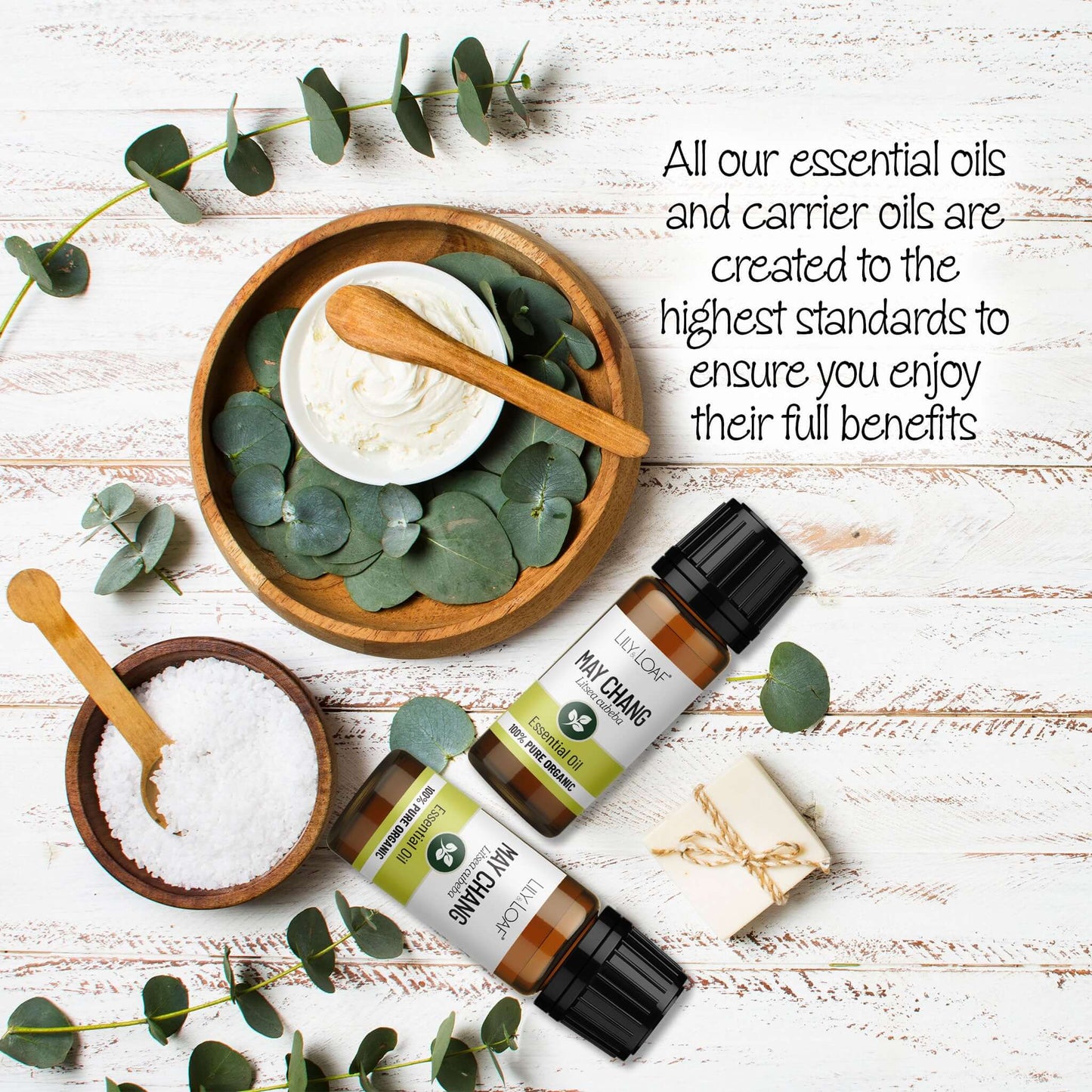 May Chang Essential Oils with eucalyptus leaves on a wooden surface