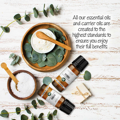 Myrrh Essential oil surrounded by eucalyptus leaves and wooden bowls on a wooden surface