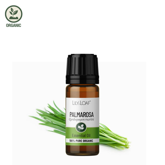 Lily Loaf Palmarosa essential oil bottle with green leaves on a white background