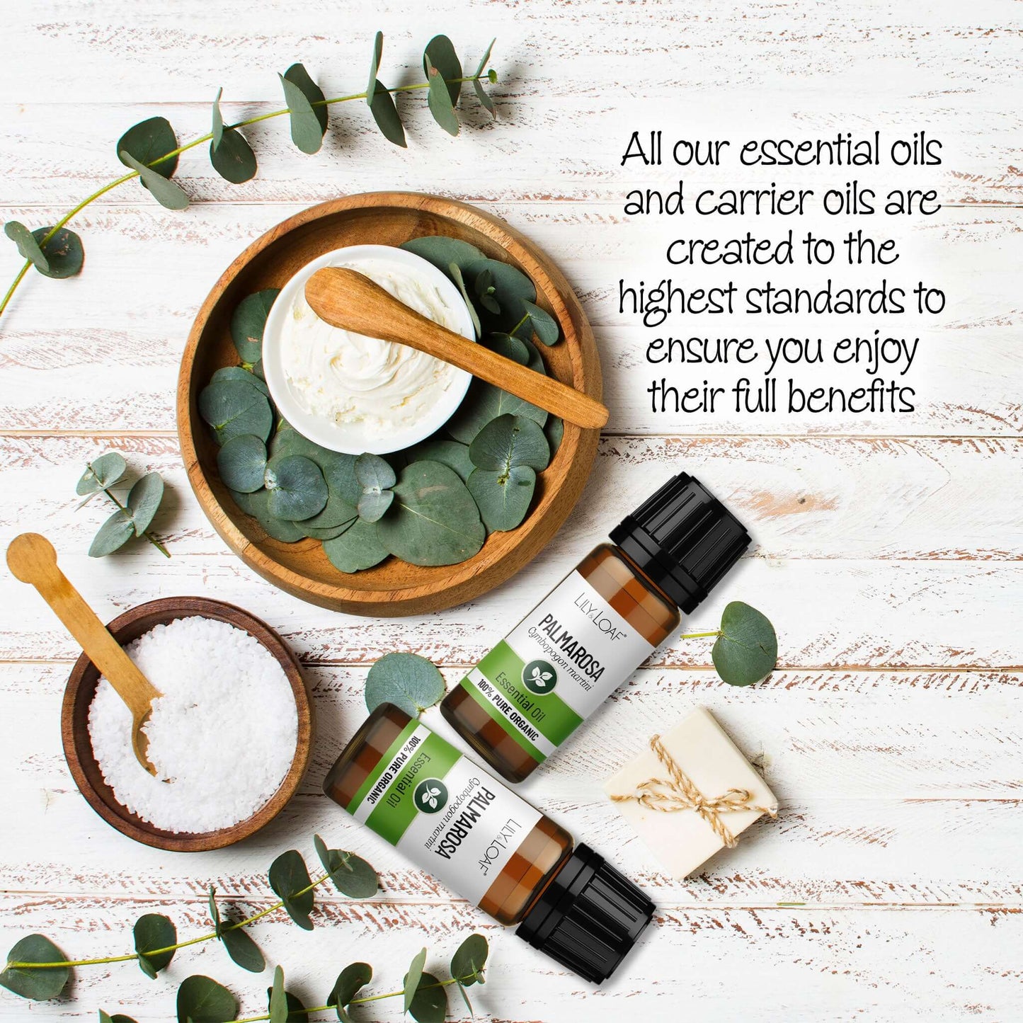 Palmarosa Essential oil surrounded by  eucalyptus leaves and wooden bowls on a wooden surface