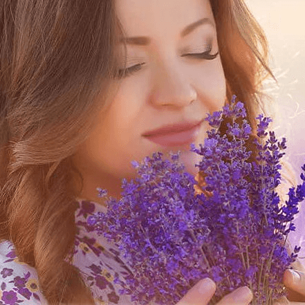 Woman enjoying the scent of fresh lavender, symbolising relaxation, aromatherapy, and the calming benefits of nature