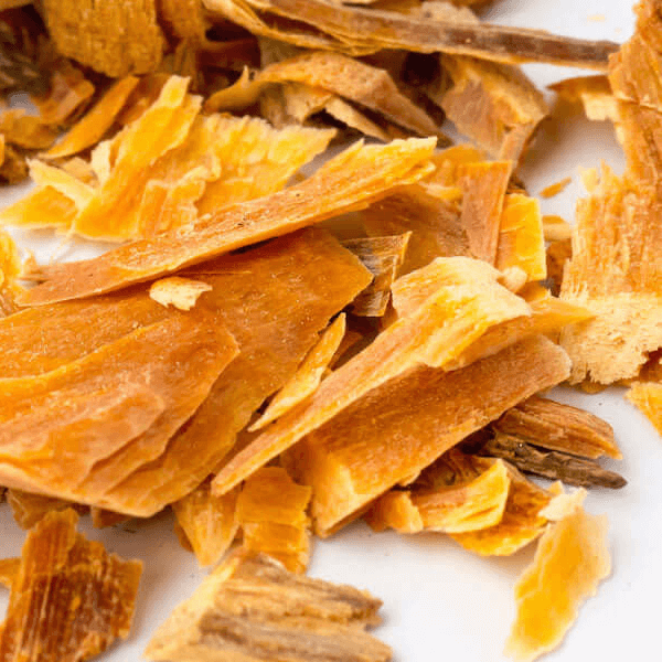 Close-up of golden cedarwood chips on a white background