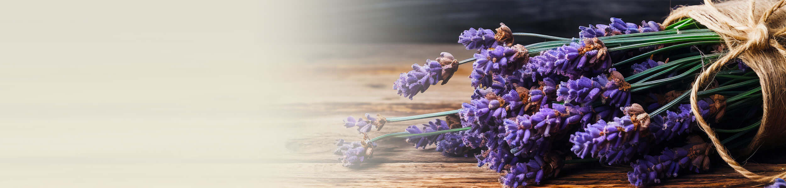 A bundle of fresh lavandin flowers tied with twine, resting on a rustic wooden surface, showcasing their vibrant purple hues
