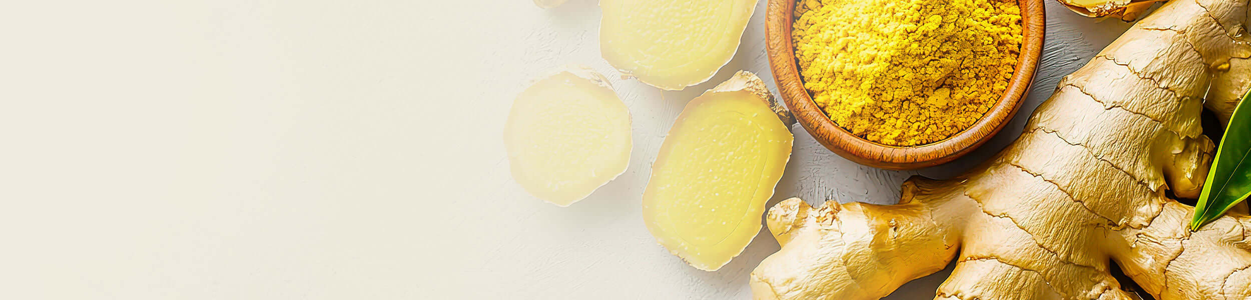 Fresh ginger root and powdered ginger in a wooden bowl, showcasing the natural essence of Ginger Essential Oil.
