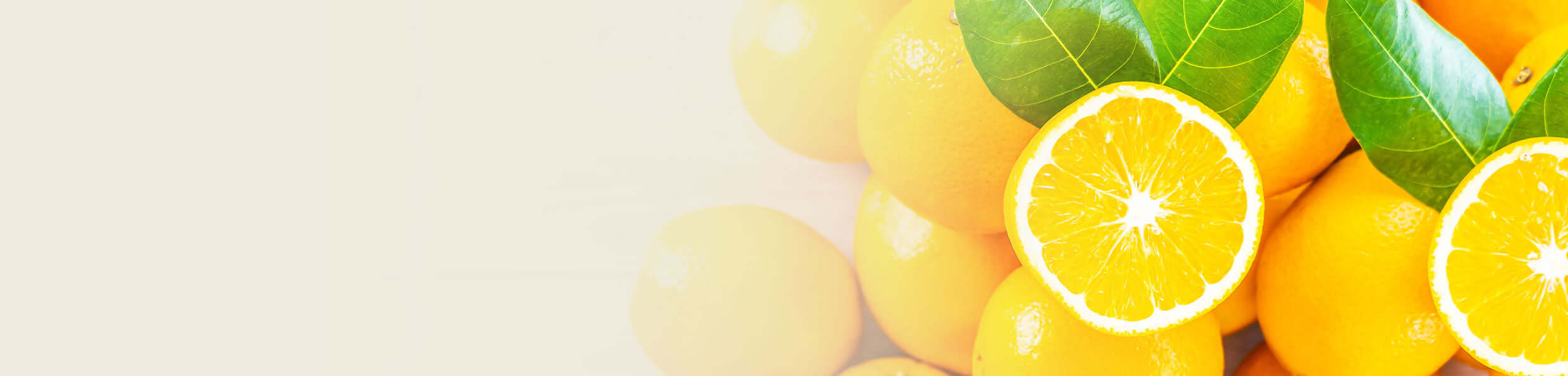 Fresh sweet oranges with green leaves, featuring a sliced orange in the foreground, promoting the Sweet Orange Essential Oil Guide.