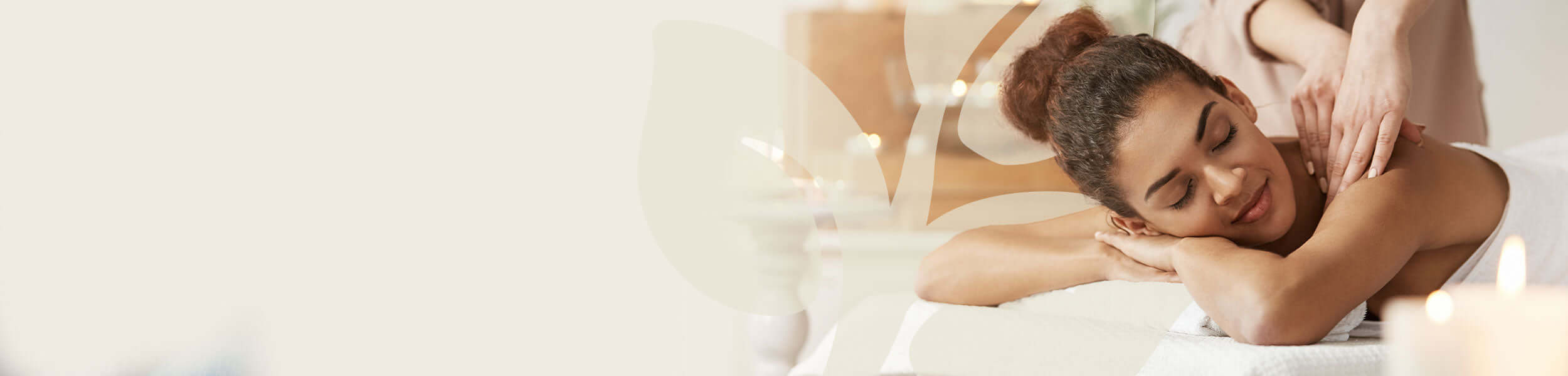 Woman enjoying relaxing back massage in a candle-lit spa setting, representing essential oil blend use for wellbeing.