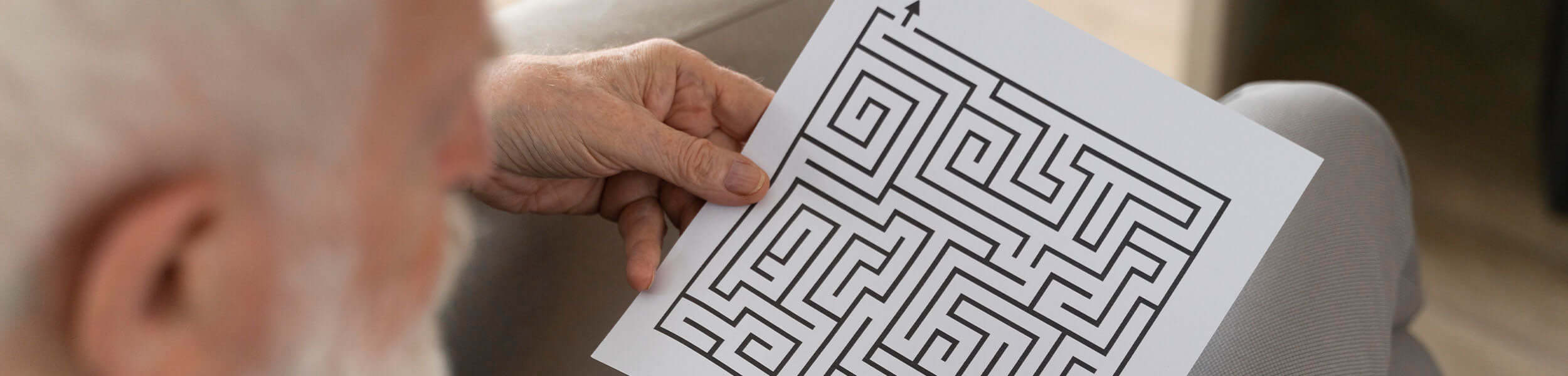 A man looking at a copy of a puzzle maze