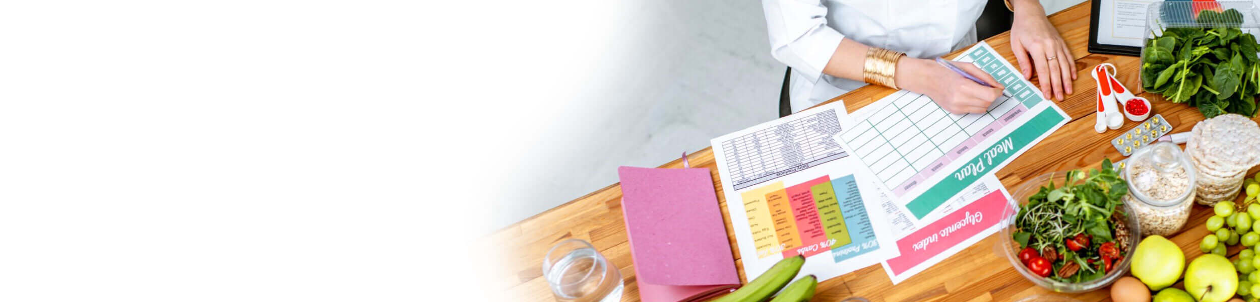 Nutritionist creating a healthy meal plan with fresh fruits, vegetables, and supplements.