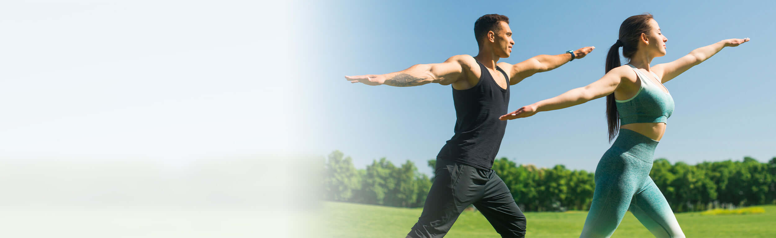 couple in workout clothes doing yoga outdoors