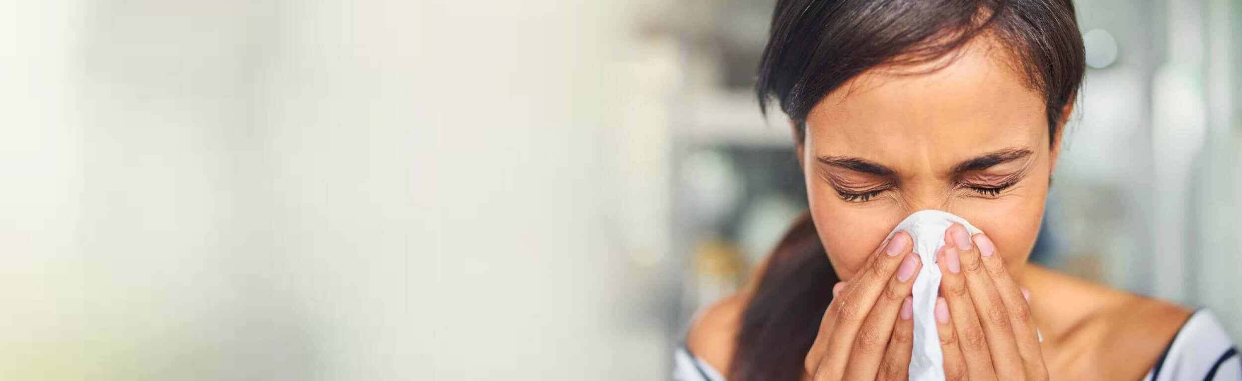 a lady blowing her nose into a tissue