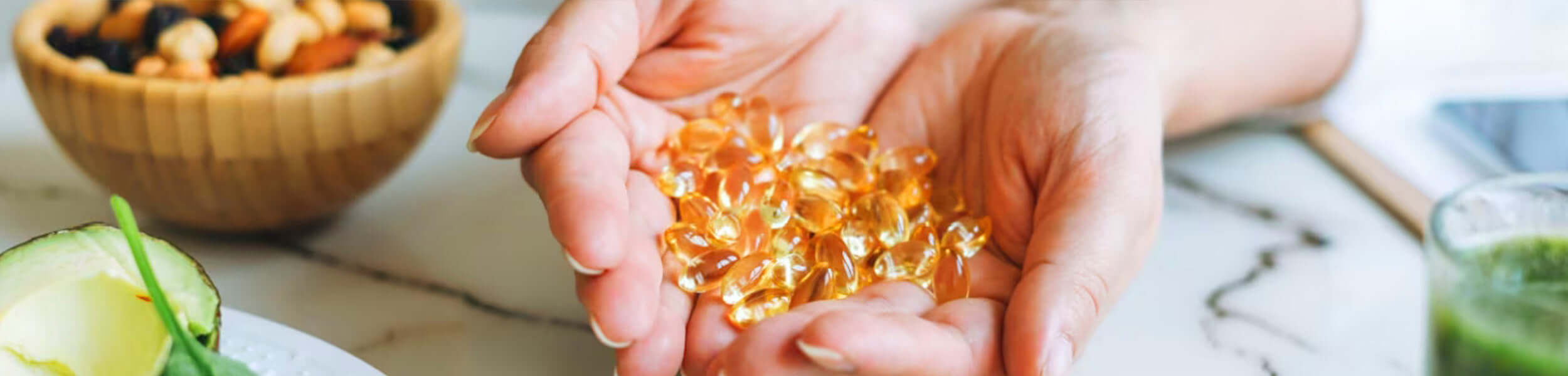 A person holding a handful of softgel capsules