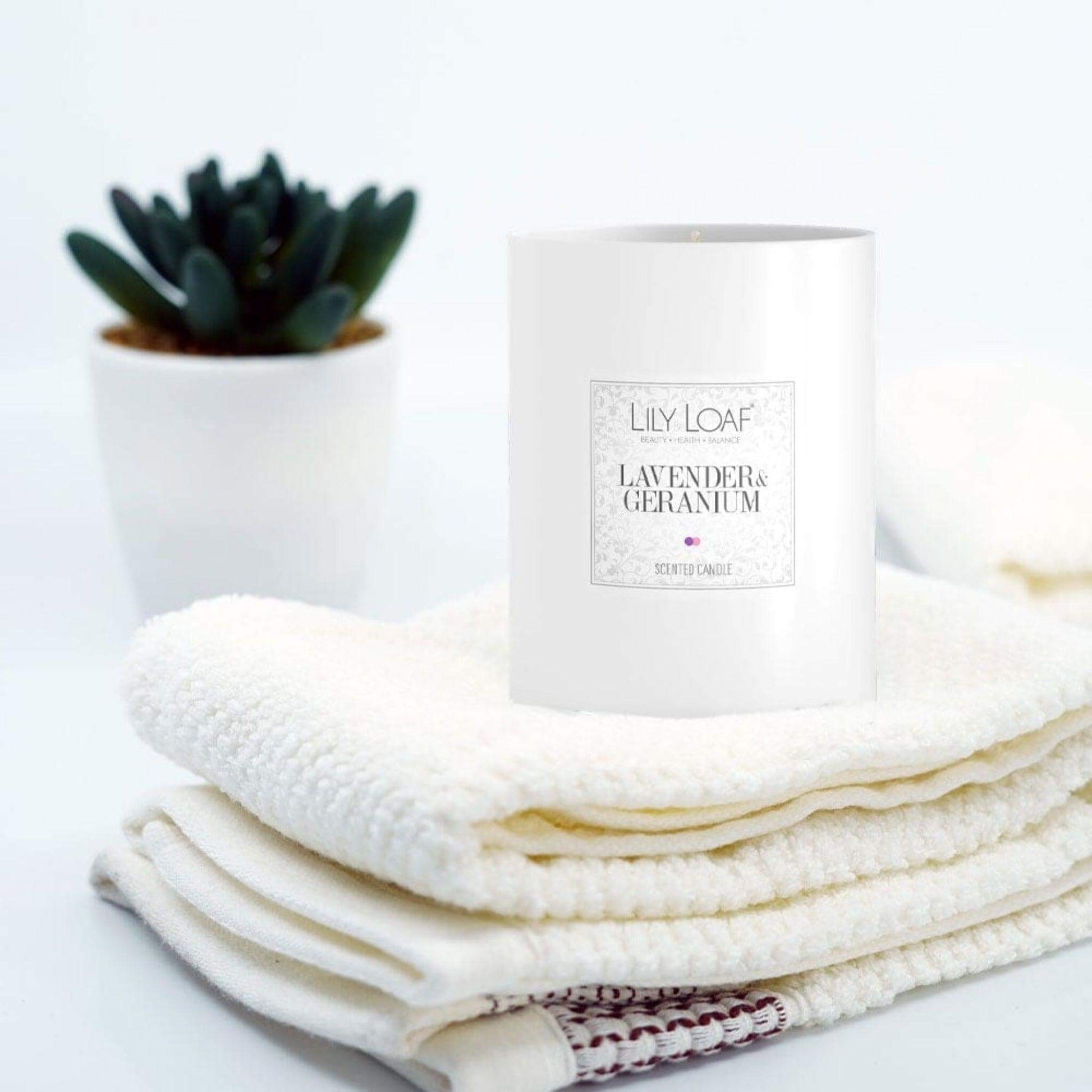 Lavender & Geranium Soy Wax Candle placed on folded towels